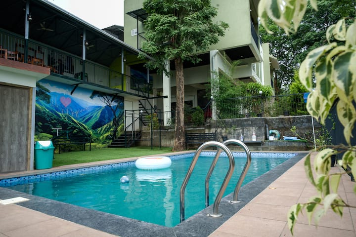 Swimming Pool Area with Mural, Foliage, and Resort Building