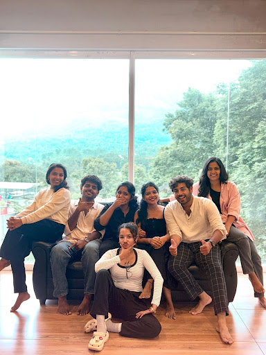 Group of Friends Posing by a Large Window with Hill View