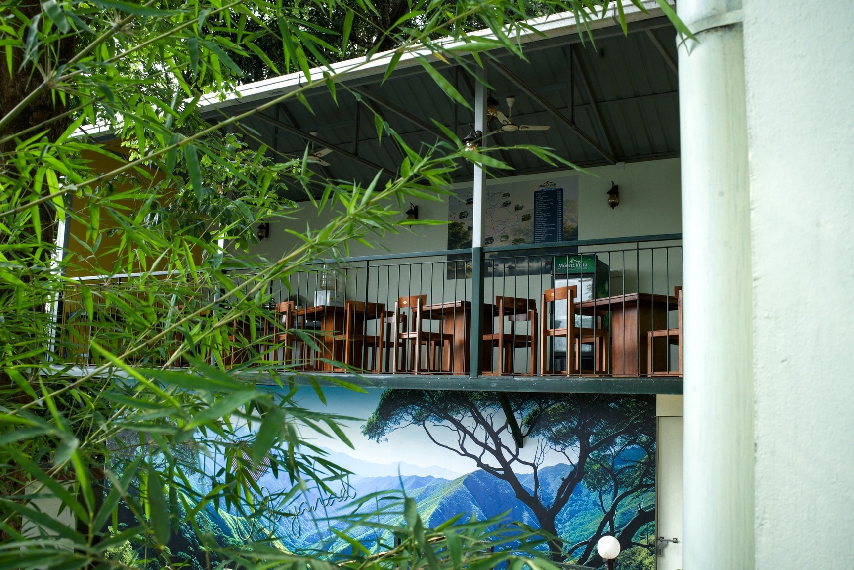 Exterior View of Balcony Restaurant Area with Green Mural and Bamboo